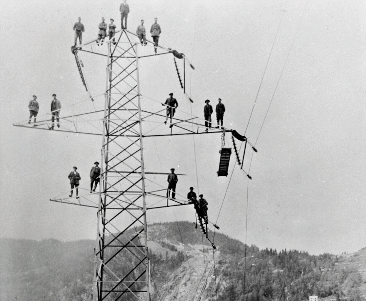 Black and white photo of men in power mast